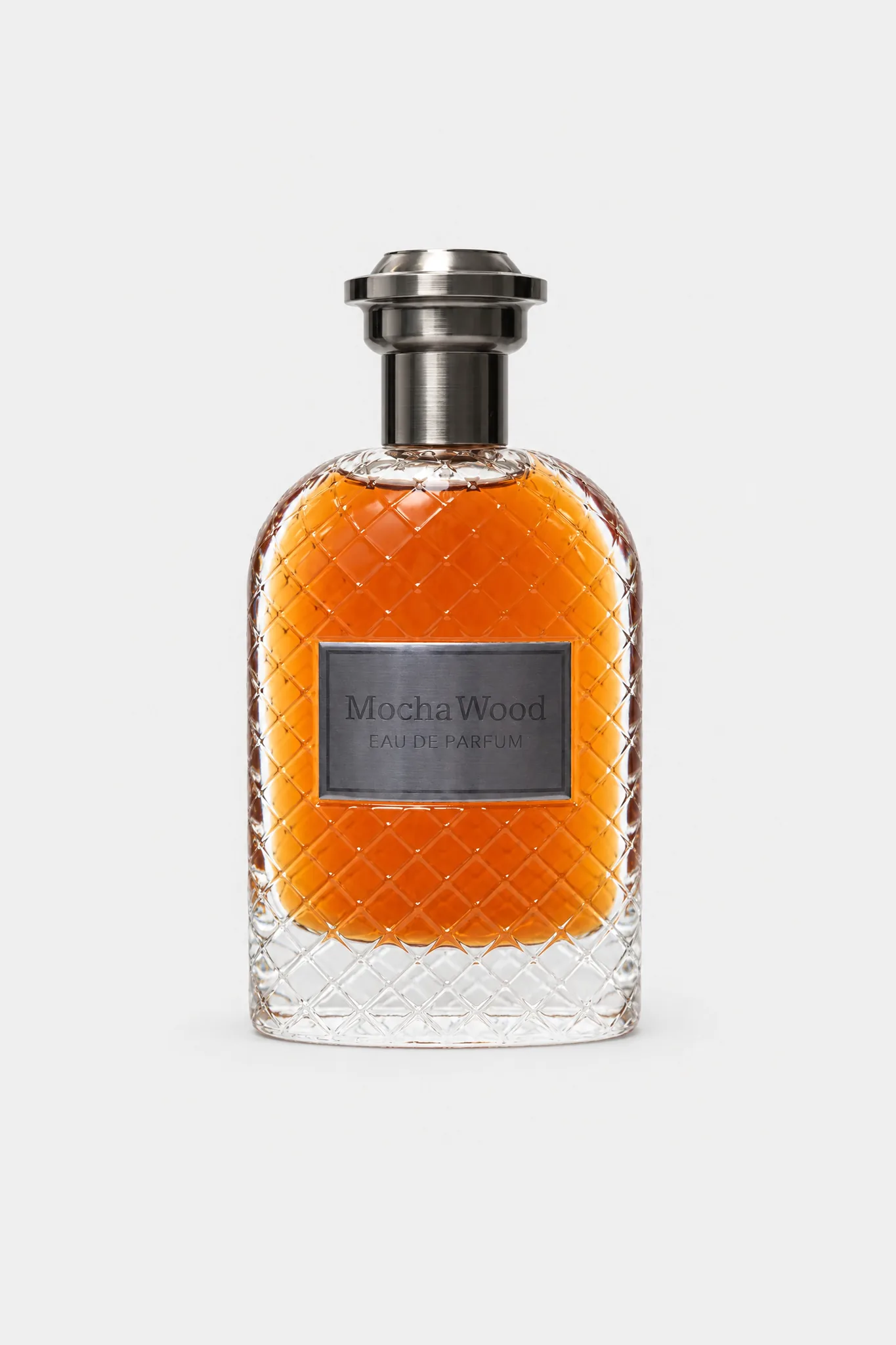 Fragrance World Mocha Wood Eau de Parfum 100 ml, diamond-cut glass with amber liquid, gunmetal cap and dark plate, front view