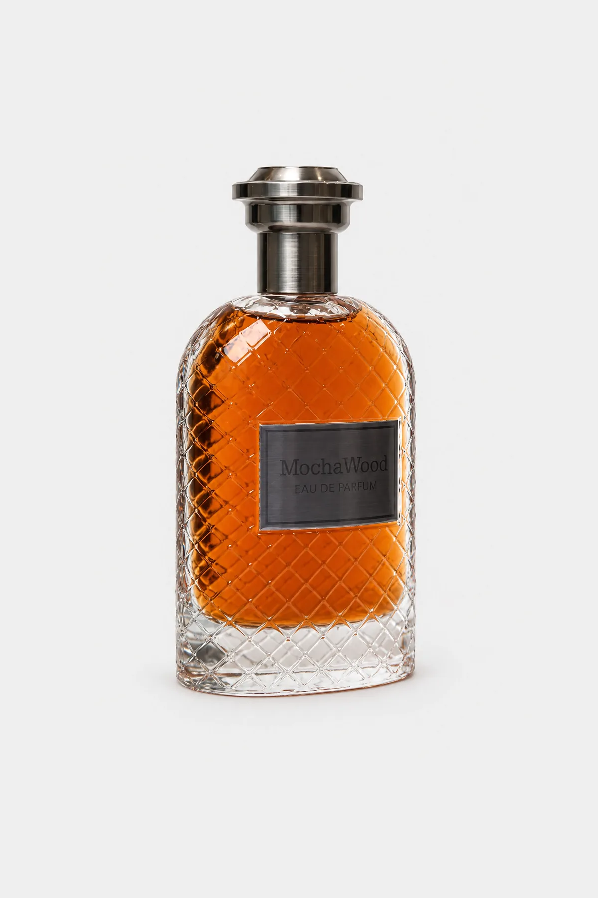Fragrance World Mocha Wood Eau de Parfum 100 ml, diamond-cut glass with amber liquid, gunmetal cap and dark plate, three-quarter view